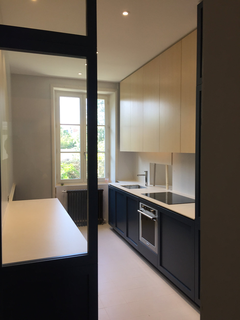Cuisine sur mesure en bois laqué, plan de travail en céramique.